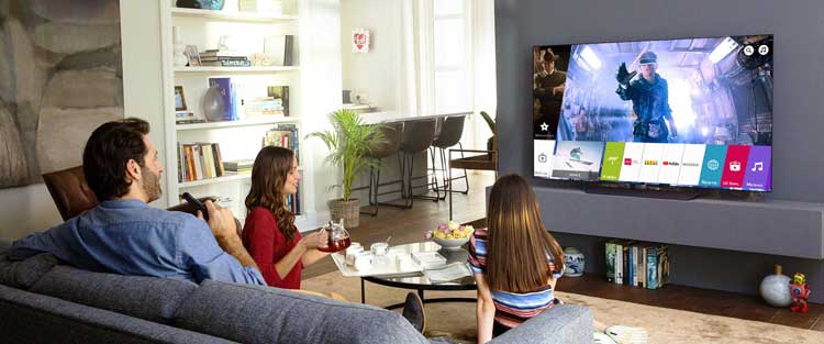 یک خانواده در حال تماشای تلویزیون در منزل